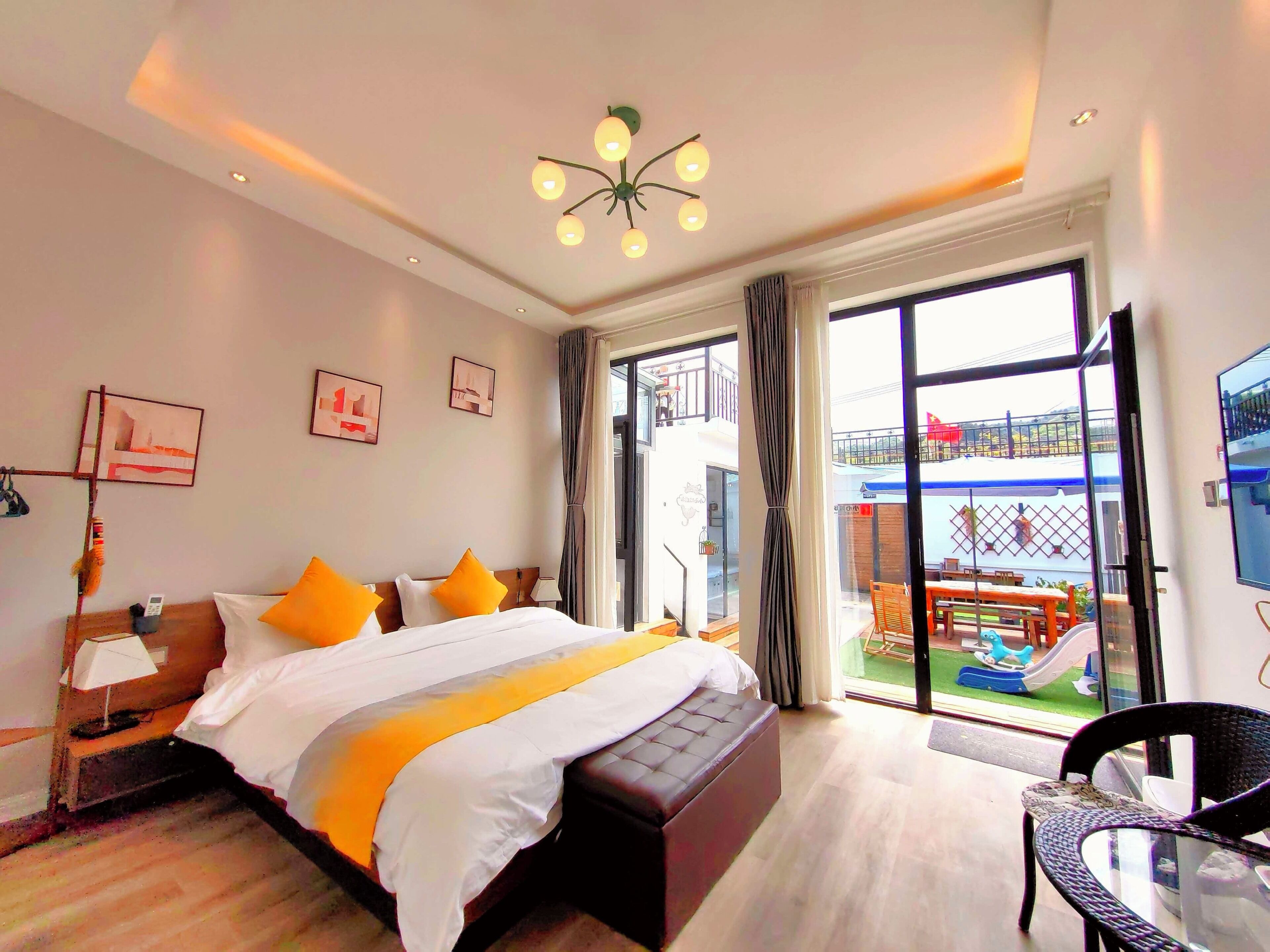 Habitación de hotel con cama, un banco, un escritorio y vistas al exterior.