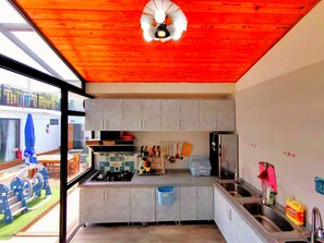 A modern kitchen with a gas stove, stainless steel sink, and a ceiling fan.