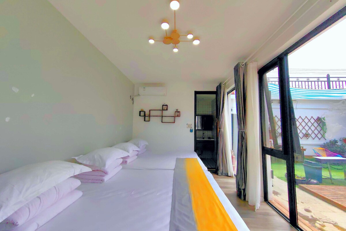 Habitación de hotel con una cama grande, una lámpara en el techo, una ventana con cortinas y vistas al exterior.