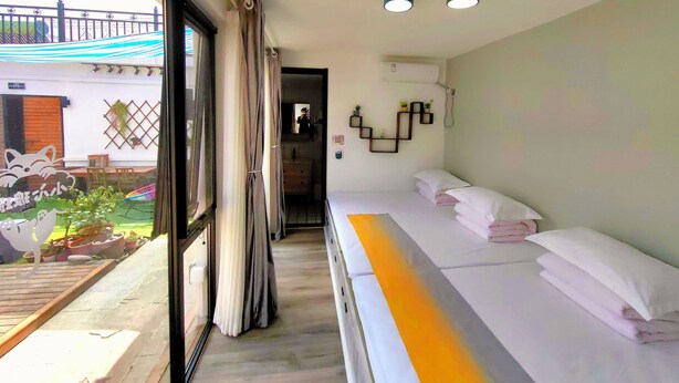 A hotel room with a bed, a bathroom, and a view of the outside. - Mutianyu Great Wall View Lodge (Huairou)