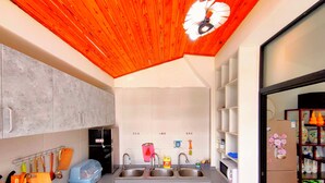 A kitchen with a wooden ceiling, white cabinets, a double sink, and a refrigerator. - Mutianyu Great Wall View Lodge (Huairou)