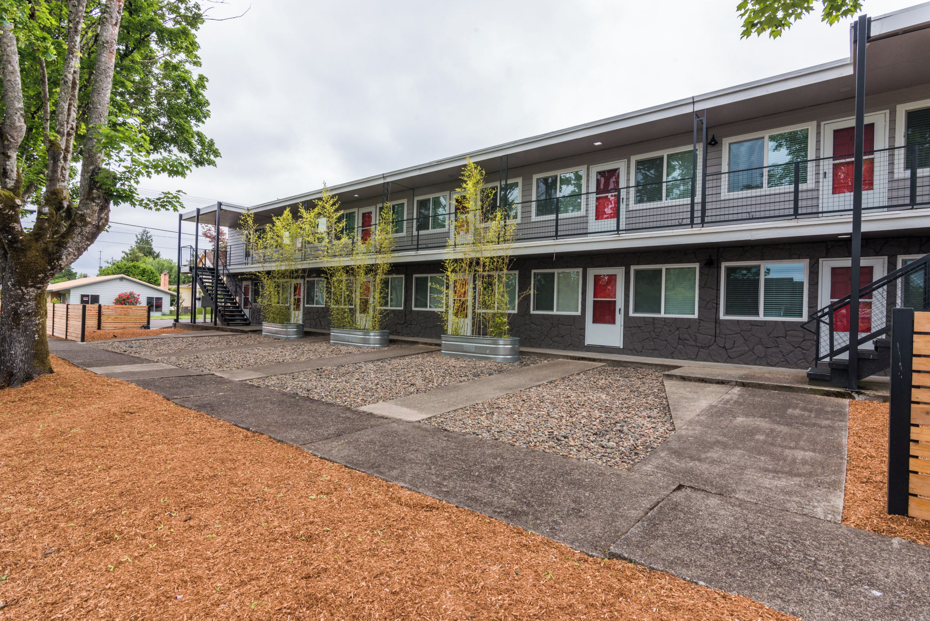 En bygning med flere etager i moderne arkitektur, med fladt tag, store vinduer og en central trappe.