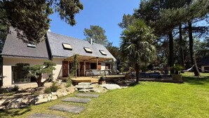 A house with a covered porch, a stone pathway, and a well-maintained lawn. - Vrbo Property (Molac)