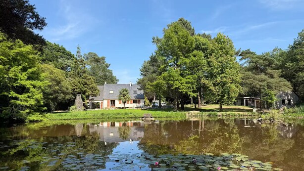 A house with a pond in front, surrounded by trees. - Vrbo Property (Molac)