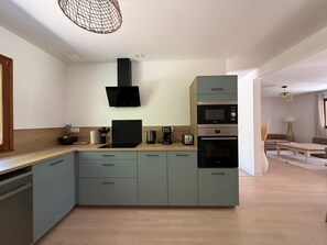 A modern kitchen with a built-in oven, microwave, and a coffee maker. - Large house with a private pond (Molac)