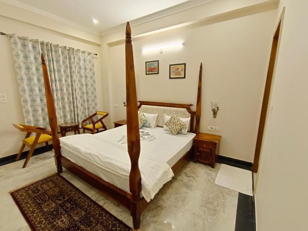 A four-poster bed with a white bedspread, a wooden headboard, and two bedside tables with lamps.