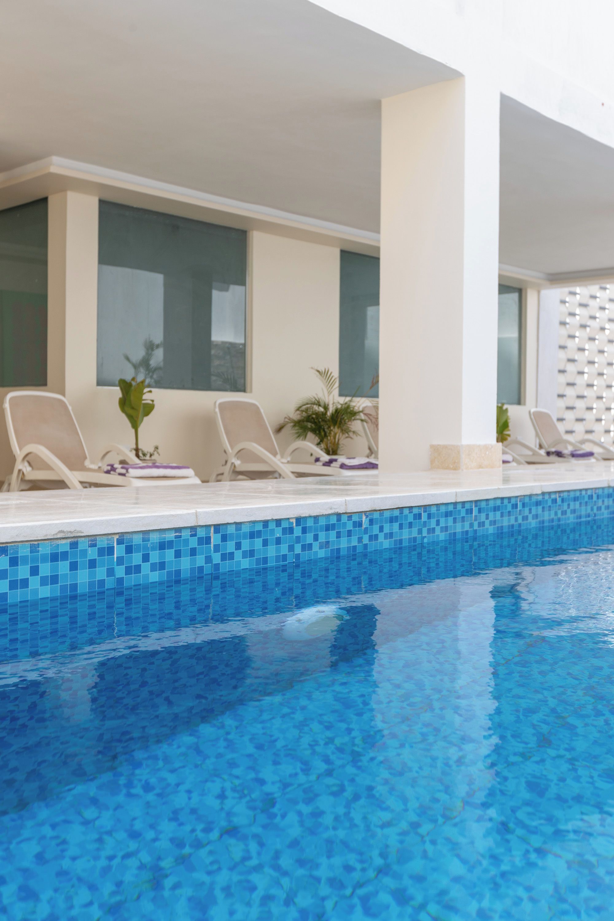 A poolside area with lounge chairs and a tiled pool.