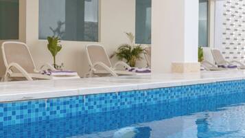 A poolside area with lounge chairs and a tiled pool.