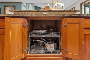 A kitchen with wooden cabinets, a granite countertop, and a built-in oven with racks.