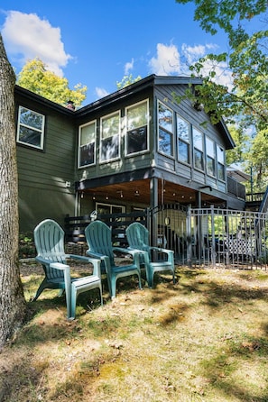 A two-story house with a covered porch and outdoor seating area.