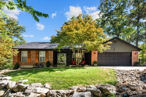 A residential house with a brick exterior, a front porch, and a garage. - Luxurious Lakefront House on Private Lake Lorraine near all Innsbrook Amenities! (Innsbrook)