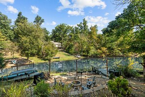 A lakeside outdoor area with a fire pit, seating, and a canoe. - Luxurious Lakefront House on Private Lake Lorraine near all Innsbrook Amenities! (Innsbrook)