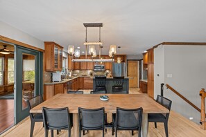 A modern kitchen with wooden cabinets, a central island, and pendant lighting. - Luxurious Lakefront House on Private Lake Lorraine near all Innsbrook Amenities! (Innsbrook)