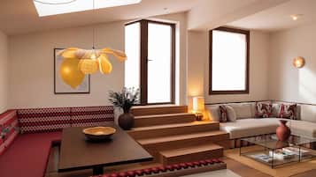 Uma sala de estar moderna com sofá, mesa de centro e escada que leva a outro andar.