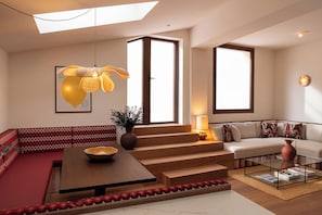 A modern living room with a sofa, a coffee table, and a staircase leading to another level. - Casa Roca (Palma de Mallorca)