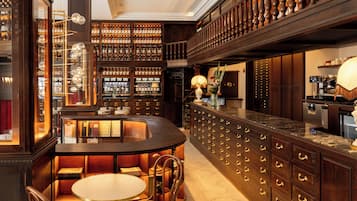 Zona de bar con mostrador curvo, asientos y exhibición de vinos.