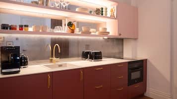 Una cocina moderna con lavavajillas integrado, una cafetera y un tostador en la encimera.