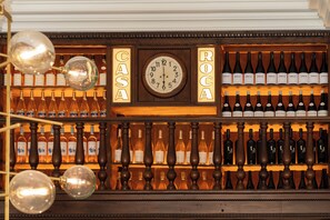 A wine rack with various bottles and a clock.