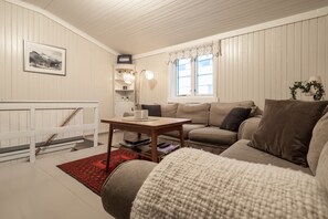 Una sala de estar acogedora con un sofá, una mesa de centro y una estantería.
