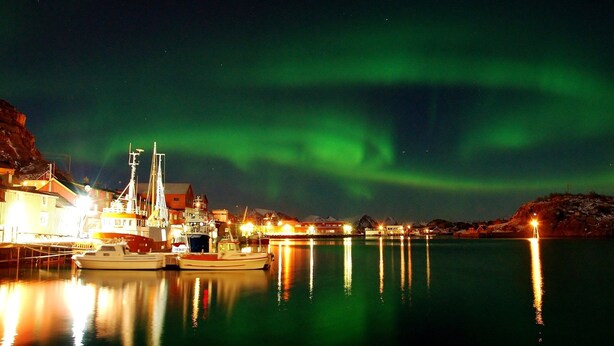 A harbor at night with boats docked, buildings, and the aurora borealis. - Cozy seaside cabin in Stamsund (Stamsund)