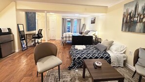 A compact living space with a bed, a sofa, a dining table, and a kitchenette. - Private Lower-Level Studio Bath, Kitchenette & Laundry (Woodbridge)