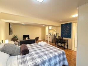 Ein Schlafzimmer mit einem Bett, einem Schreibtisch, einem Stuhl und einem Bild an der Wand.