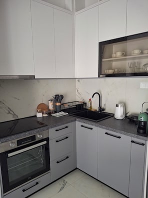 A modern kitchen with a built-in oven, a stovetop, and a sink. - Cozy 1-bedroom apartment in fantastic Kotor with AC (Kotor)