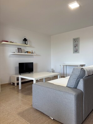 A modern living room with a grey sofa, a flat-screen TV, white shelves, and a framed artwork on the wall. - SOUTHERN STAR (Valle La Lajita)