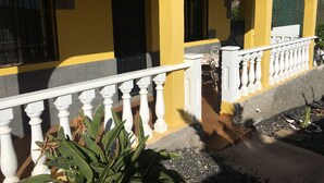 A yellow building with white railings and a covered patio area. - STAR OF THE SOUTH (Valle La Lajita)