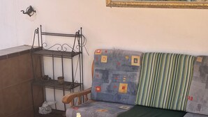 A cozy seating area with a sofa, two chairs, and a wooden table with two bottles. - STAR OF THE SOUTH (Valle La Lajita)