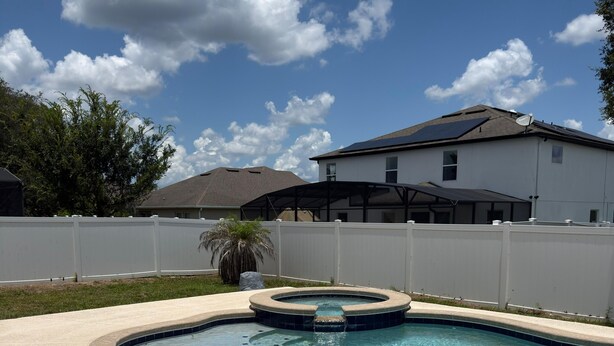 A swimming pool with a hot tub, surrounded by a white fence, and a house in the background. - CLOSE TO DISNEY Cozy 3 bed/3 bed house in tranquil Apopka w fitness room/ pool (Apopka)
