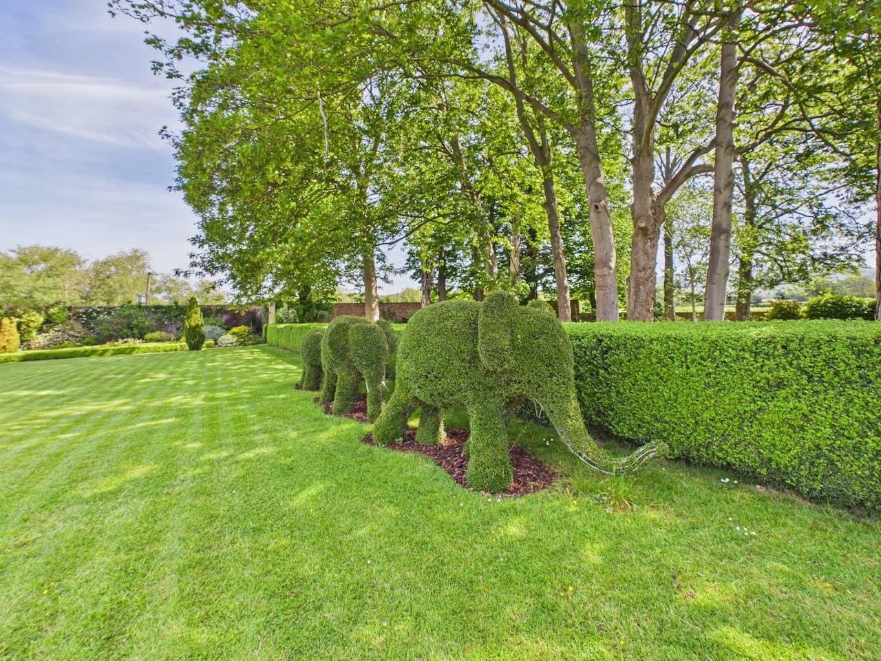 A well-maintained garden with topiary elephant sculptures.