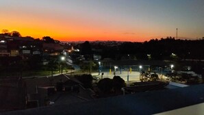 A residential area during twilight with houses and streetlights.
