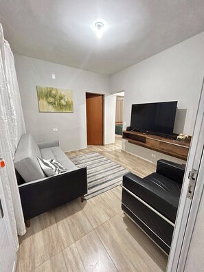 Un saló amb un sofà, una televisió i un quadre a la paret.