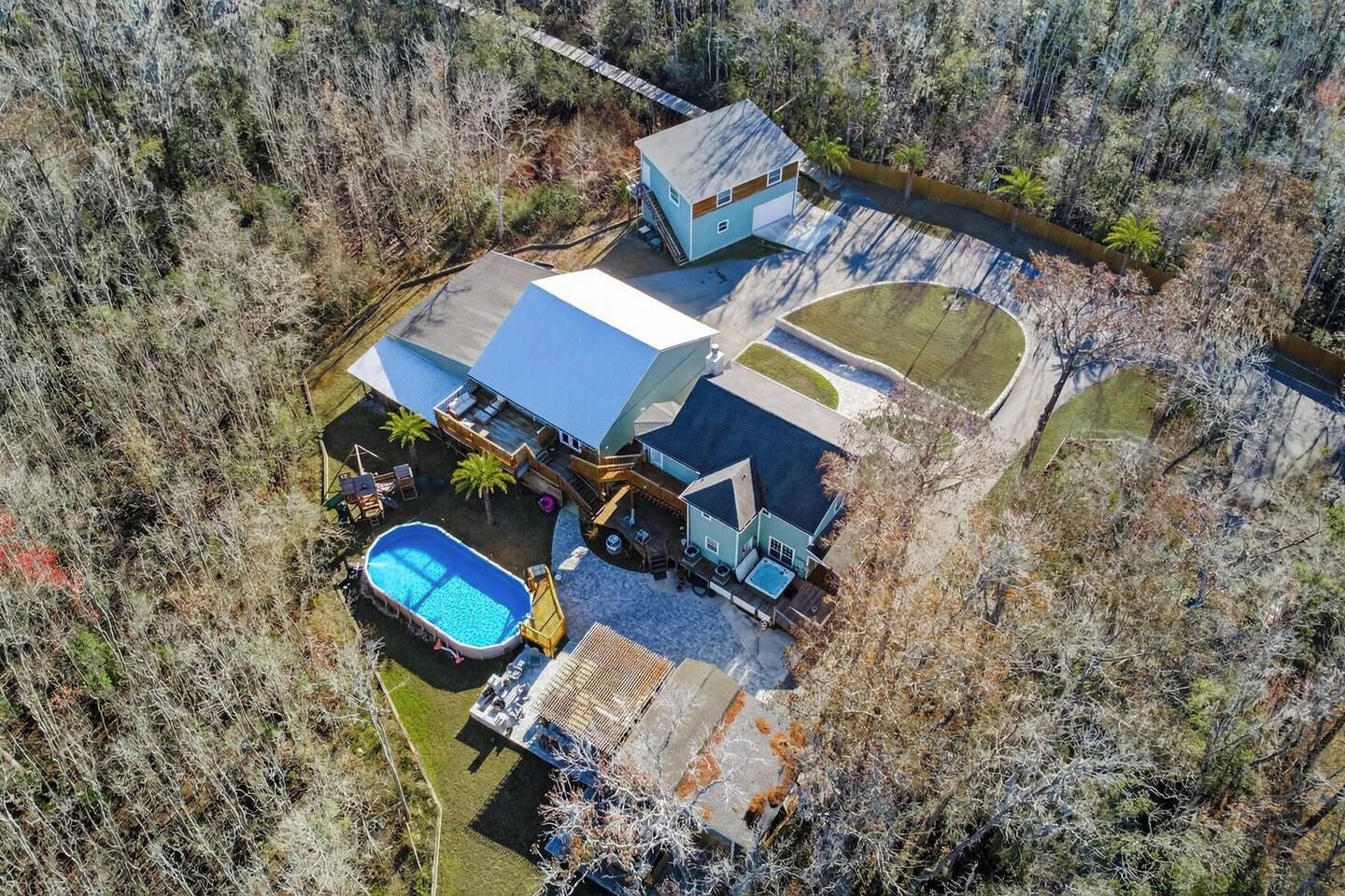 A residential property with a swimming pool, a covered patio, and a detached garage.