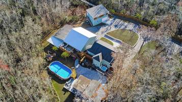 A residential property with a swimming pool, a covered patio, and a detached garage.