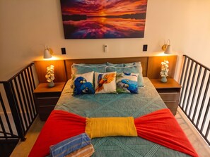 A bedroom with a bed, pillows, bedside tables, and a painting on the wall. - Sol e Mar Carneiros Duplex | 2 Suites for 6 People | 300 m from the beach | (Tamandaré)