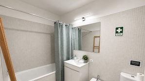A bathroom with a bathtub, sink, bidet, and toilet. - Lisbon Green Center (Lisboa)
