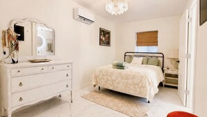 Una camera da letto con un letto, una cassettiera, uno specchio e un lampadario.