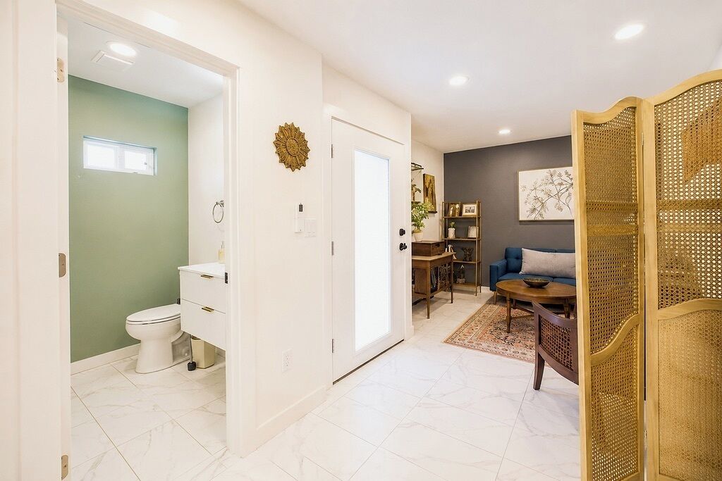 A modern interior with a bathroom, a living area with a sofa and coffee table, and a decorative partition.