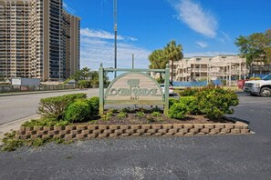 A sign for The Kenbridge with a clear view of the surrounding buildings and a parking area. - Ocean Bridge C1- Beach Across The Street- 2BR (Myrtle Beach)