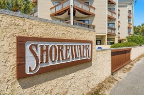 Et skilt med teksten 'Shorewalk' monteret på en struktureret væg.
