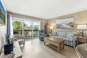 A living room with a sofa, armchair, coffee table, and a painting on the wall. - Shorewalk 5- 2 Bedroom- Beach Across The Street (North Myrtle Beach)