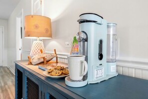 A coffee maker, a mug, cookies, and a lamp on a table. - Watergate- 4 Bedroom beach House in Cherry Grove (North Myrtle Beach)