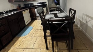 A kitchen with dark wooden cabinets, a white stove, and a dining table with chairs. - Beautiful 2-bedroom apartment near malls and restaurants in Springfield (Springfield)