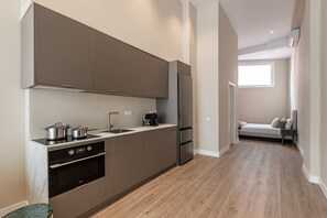 Una cuina compacta amb electrodomèstics moderns, forn integrat i un petit menjador amb seients de banc.