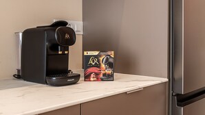 A coffee machine on a kitchen counter with a coffee capsule box beside it. - Waou Madrid Rio II - Short-Term Rental (Madrid)