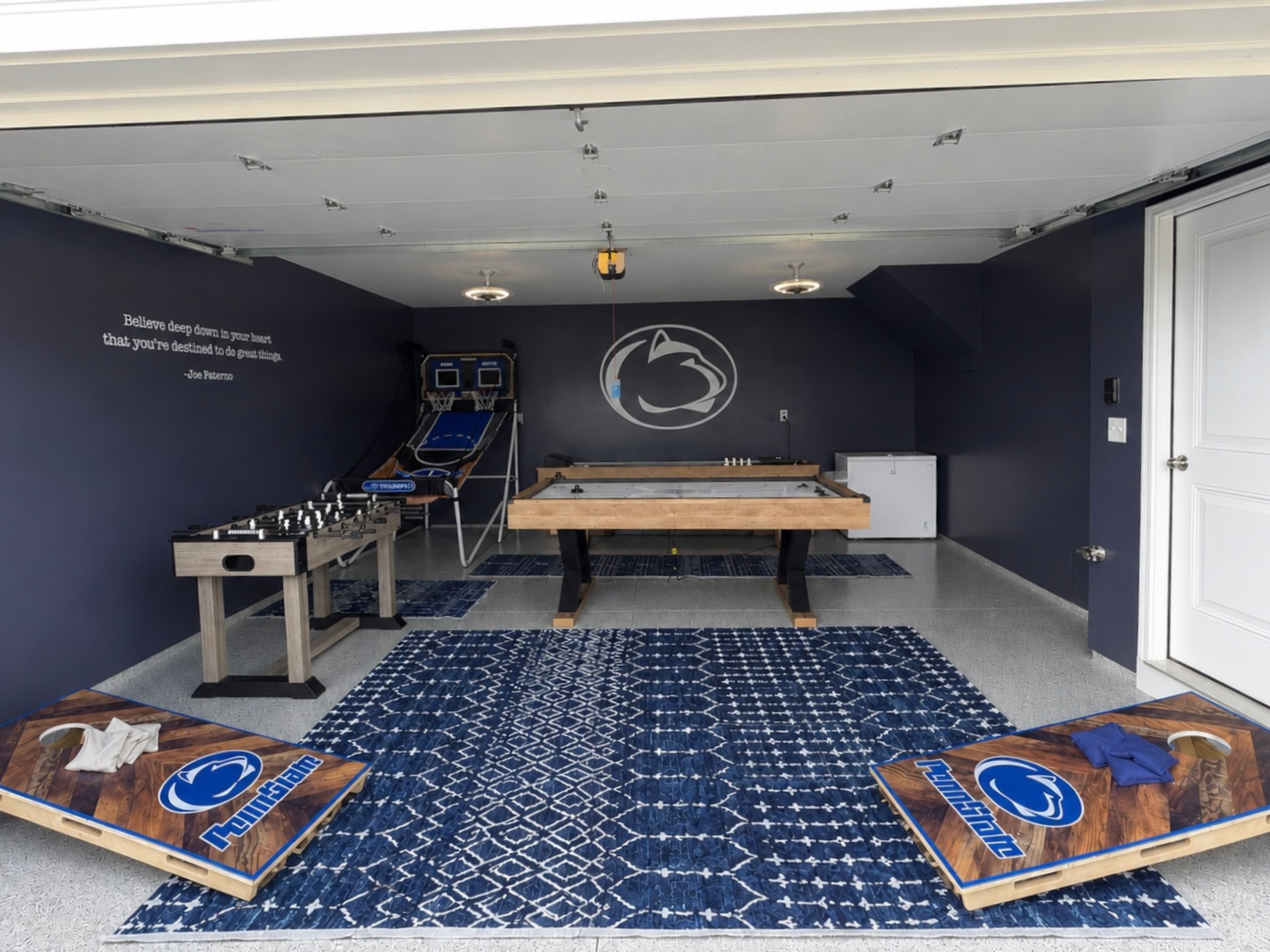 A room with a foosball table, ping pong table, and a pool table.