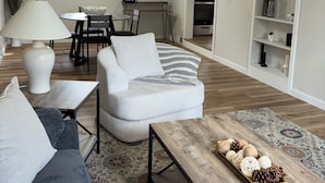 A modern living room with a sofa, a coffee table, and a dining area with a table and chairs. - Cozy, contemporary apartment outside of the Fort Wayne city center (Fort Wayne)