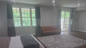 A spacious room with a large window, a sofa, and a fluffy rug. - Comfortable private retreat in the Ashburn, VA (Ashburn)